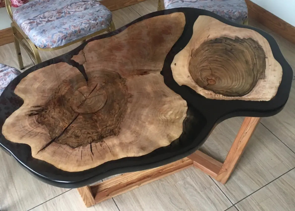 Organische handgemaakte salontafel van massief hout en zwarte epoxyhars met unieke natuurlijke vormen, scheuren en houtnerven – luxe designmeubel als blikvanger in de woonkamer.