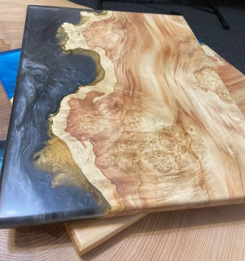 Luxe live edge epoxyhars snijplank met zwarte metallic rivier en esdoorn burl hout – handgemaakt modern houten meubel voor interieurliefhebbers en op maat gemaakte woondecoratie.