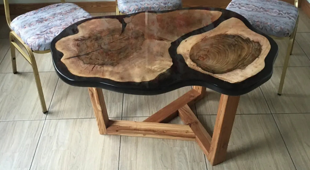 Rustieke houten tafel met een levendige rand, die natuurlijke houtnerfpatronen laat zien. Ondersteund door hoekige houten poten.