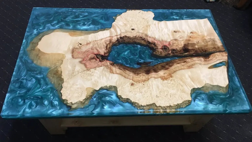 Riviersnijplank van epoxyhars in oceaanstijl met een levendige rand van esdoornhout, blauwe parelmoeren golven en artistieke eiland-geïnspireerde houtinleg voor moderne kustinterieurs en luxe woonaccessoires.