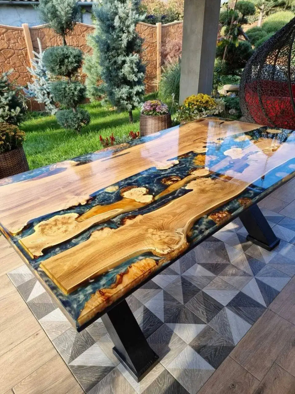 Zijaanzicht van een gladde houten vergadertafel met wervelende patronen van gepolijst zwart hars en wit hars, die doen denken aan de golven die tegen de kust van het eiland slaan. Dit creëert een rustieke maar elegante sfeer.