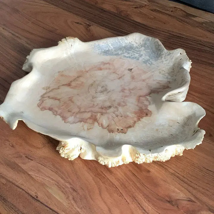 Bovenaanzicht van handgemaakte decoratieve bladvormige schaal van esdoornhout met een unieke rode en blauwe houtnerf.