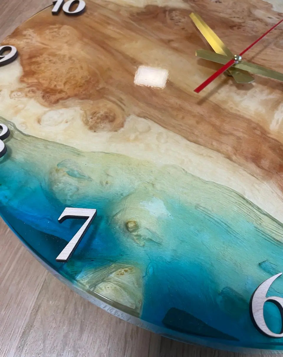Inzoomen op handgemaakte decoratieve ronde wandklok van wortelhout en levendige oceaanblauwe epoxyhars.