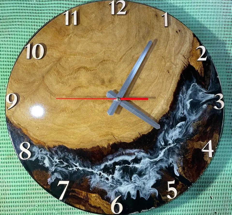 Handgemaakte analoge houten wandklok met zwarte epoxyhars, natuurlijke houtnerf en stil quartz-uurwerk met zilverkleurige en rode wijzers.