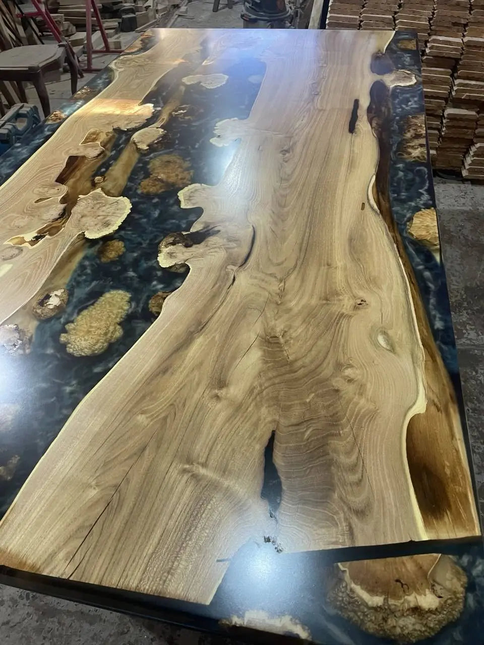The river table is handcrafted from the unique grain of acacia wood and finished with deep black epoxy resin and refined white wave details. This table evokes rugged rock formations, while the contrast between black and white evokes the mystique of nighttime tides.